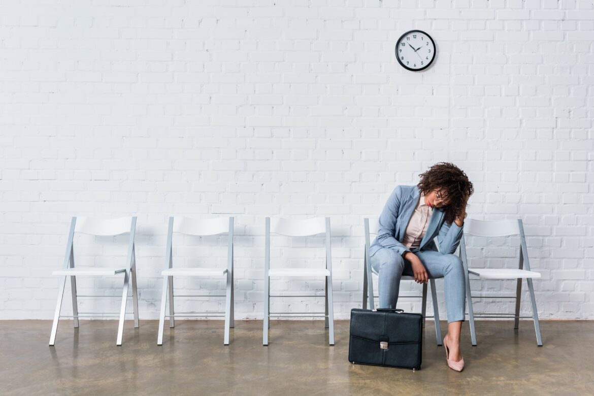 tired female candidate with briefcase waiting for job application